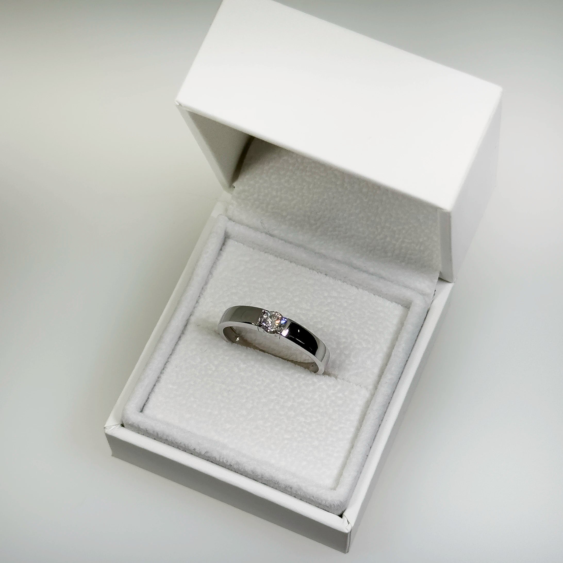 Hopeinen 0,263ct laboratoriotimanttisormus kuvattuna valkoisella korutelineellä