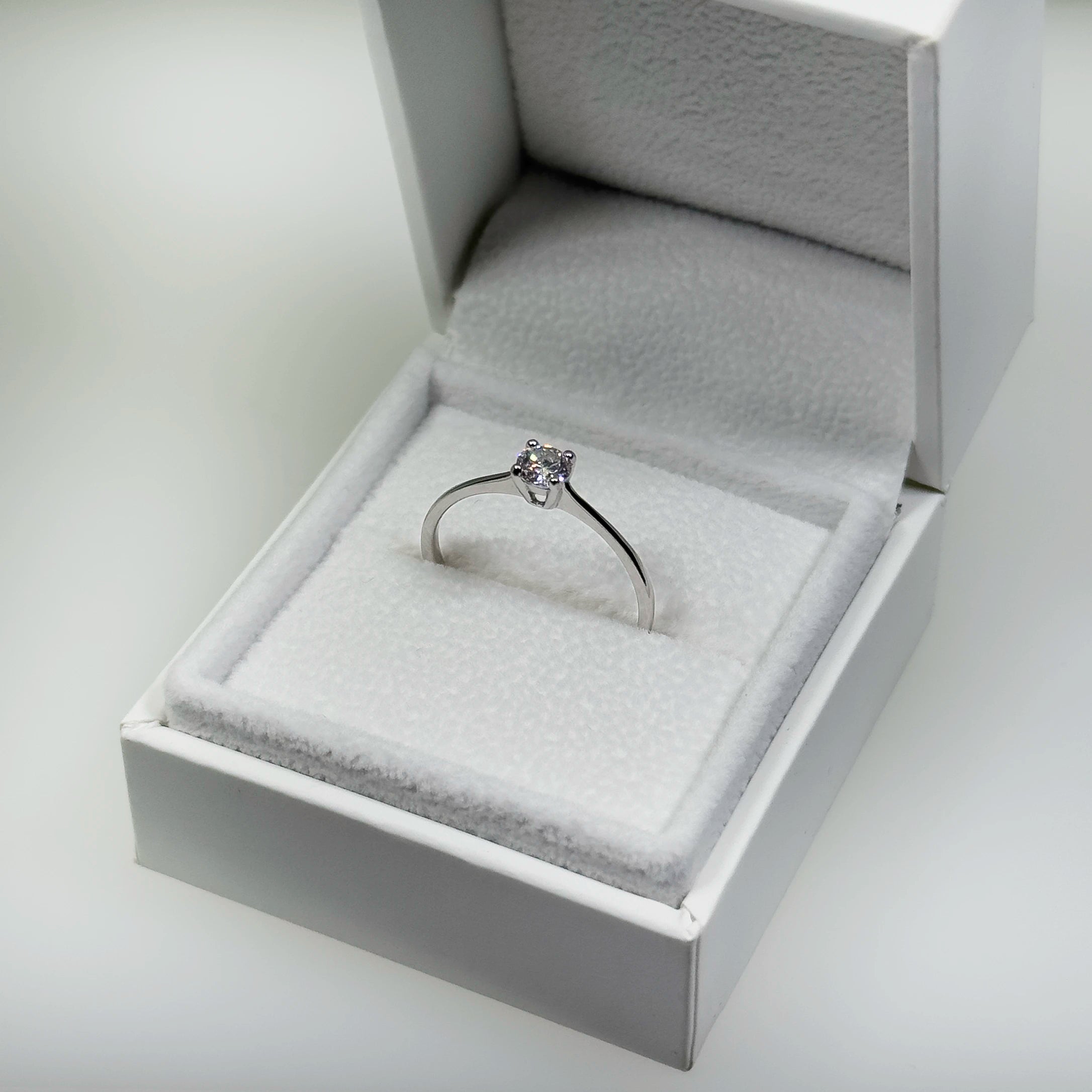 Hopeinen 0,26ct laboratoriotimanttisormus kuvattuna valkoisella korutelineellä