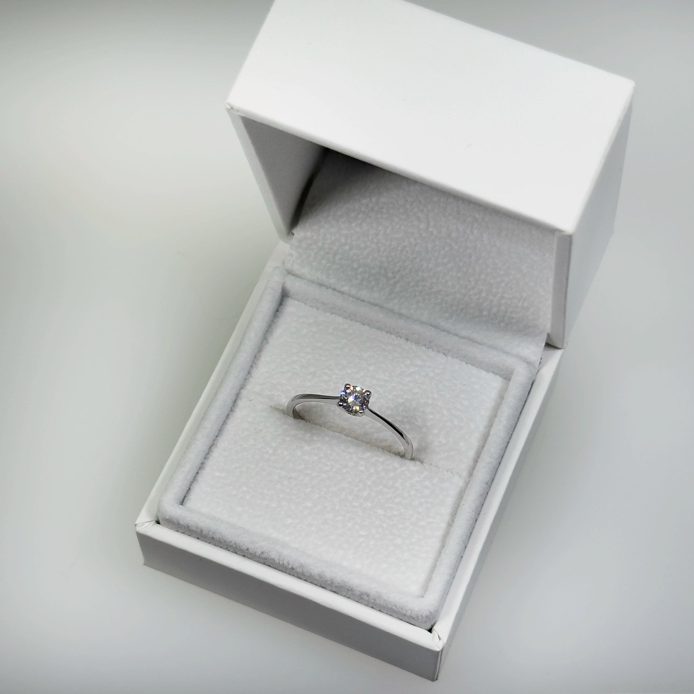 Hopeinen 0,26ct laboratoriotimanttisormus kuvattuna valkoisella korutelineellä