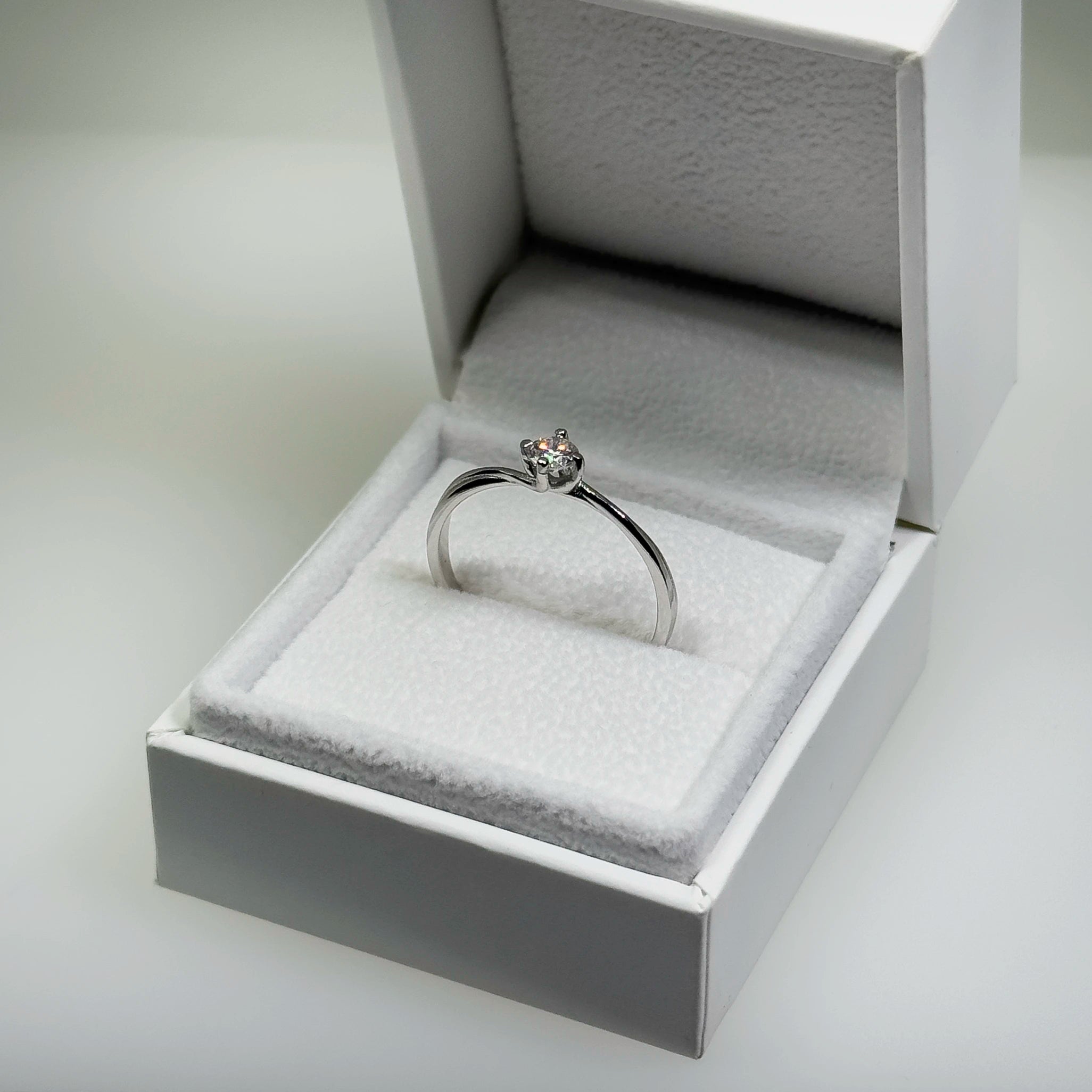 Hopeinen 0,26ct laboratoriotimanttisormus kuvattuna valkoisella korutelineellä