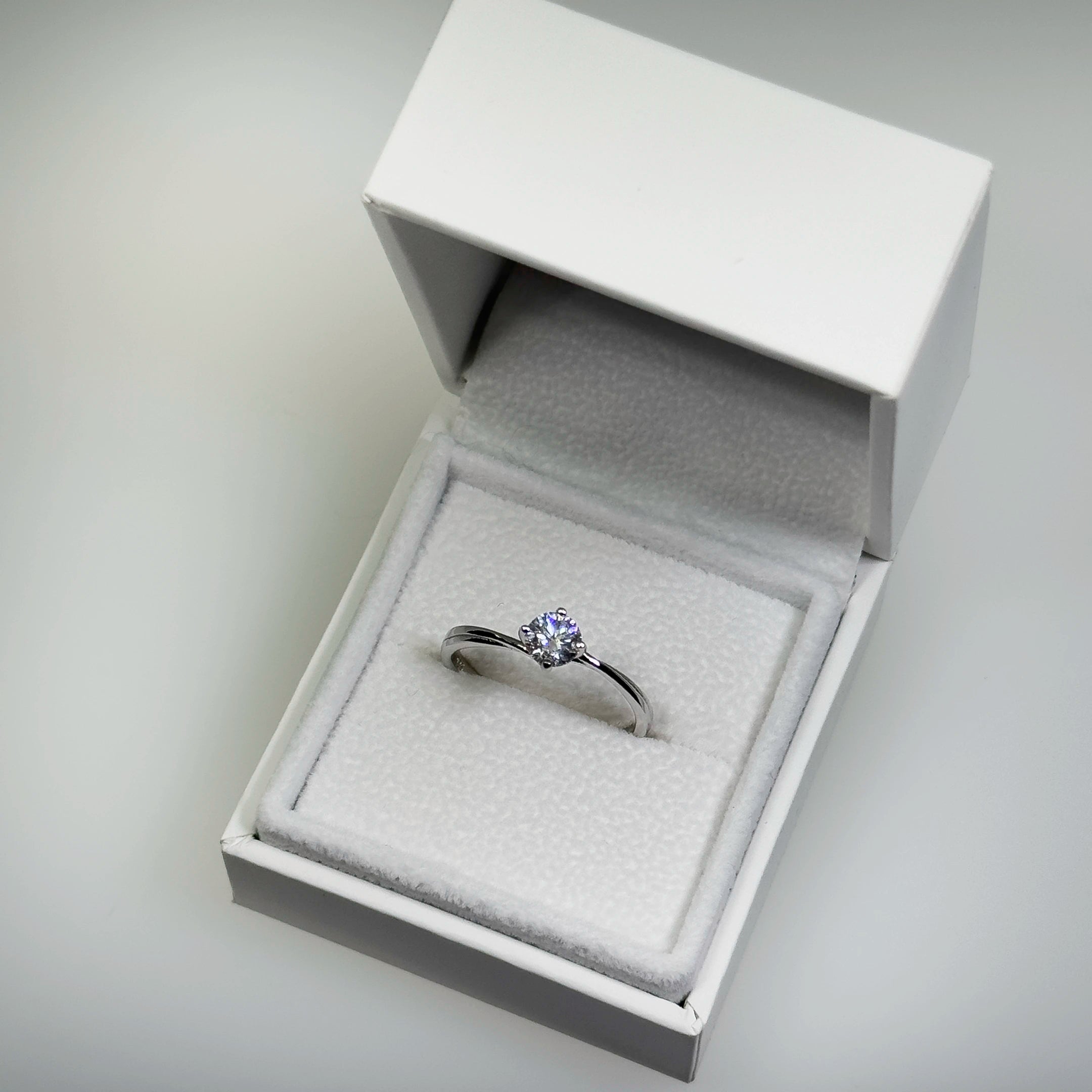 Hopeinen 0,49ct laboratoriotimanttisormus kuvattuna valkoisella korutelineellä