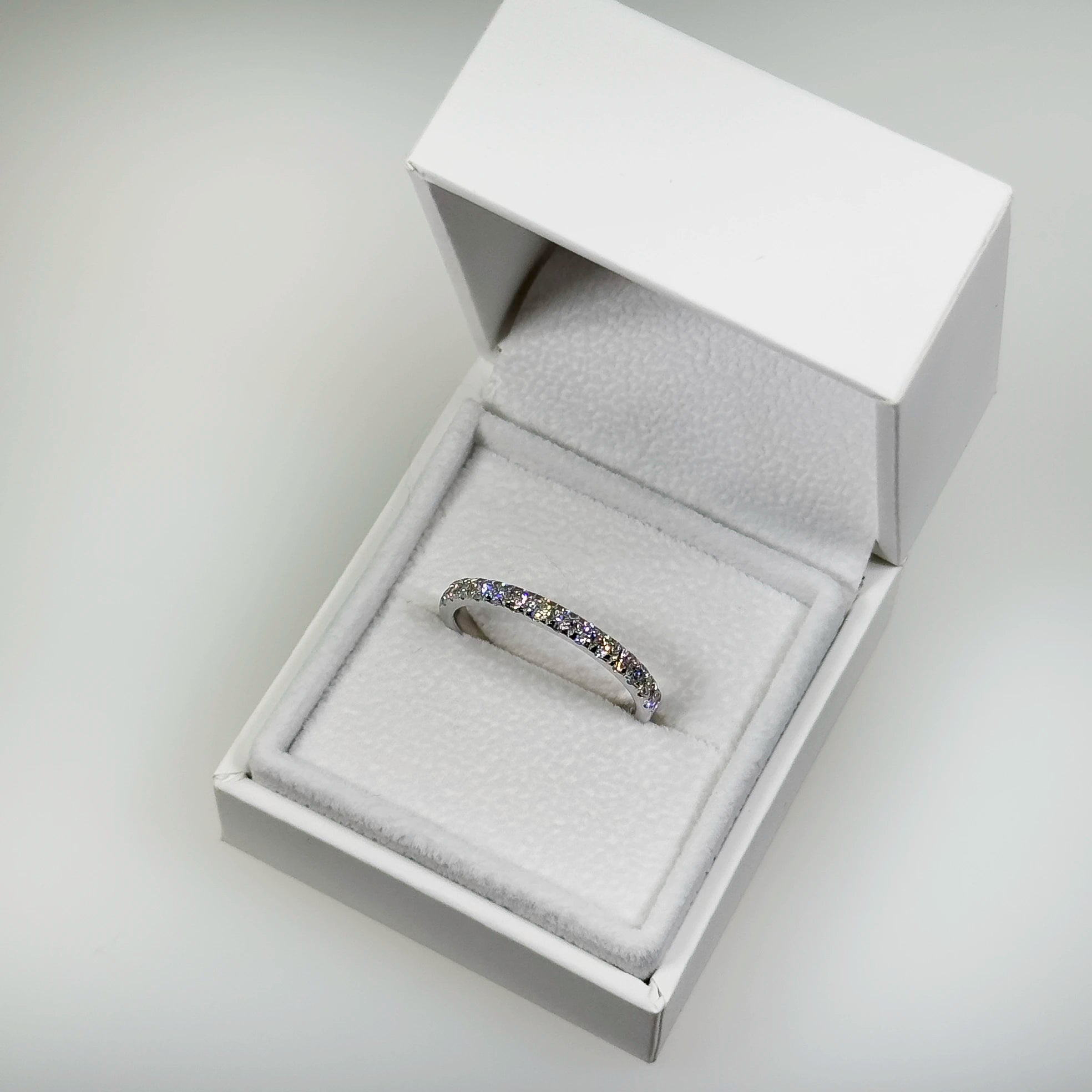 Hopeinen 0,57ct laboratoriotimanttisormus kuvattuna valkoisella korutelineellä