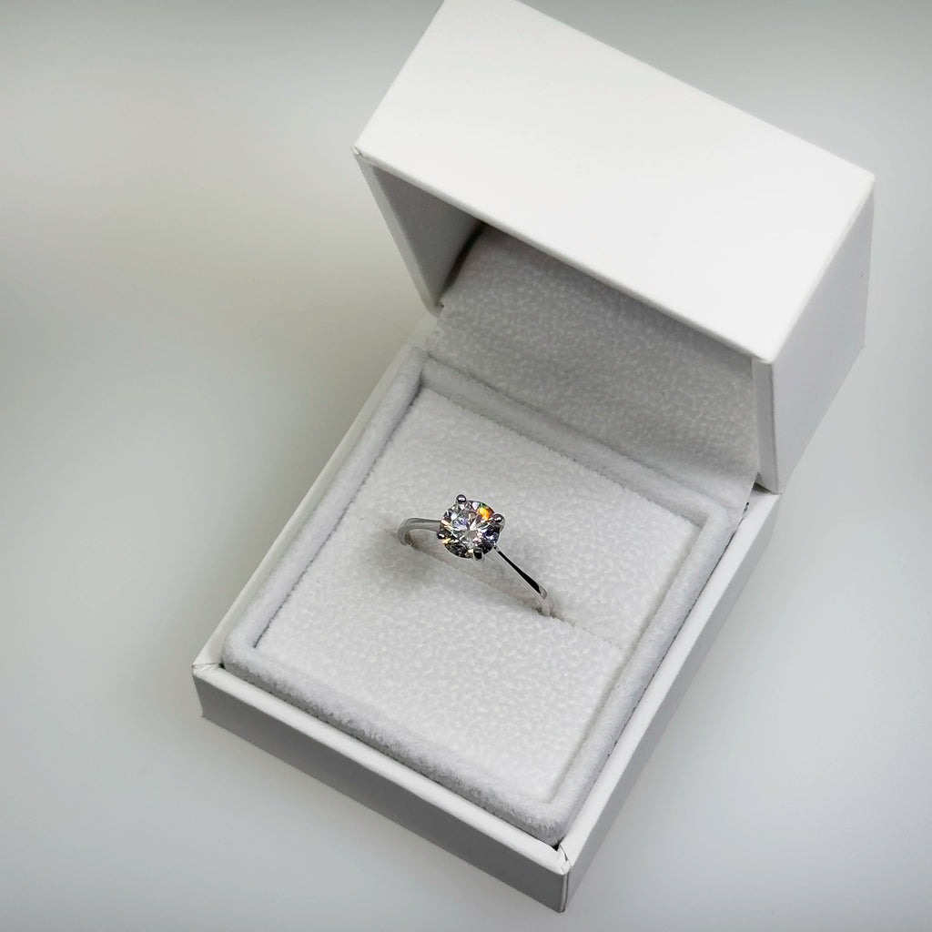 Hopeinen 1,038ct laboratoriotimanttisormus kuvattuna valkoisella korutelineellä