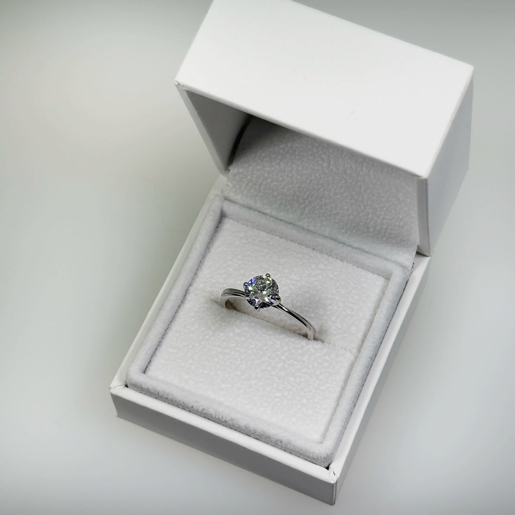 Hopeinen 1,03ct laboratoriotimanttisormus kuvattuna valkoisella korutelineellä