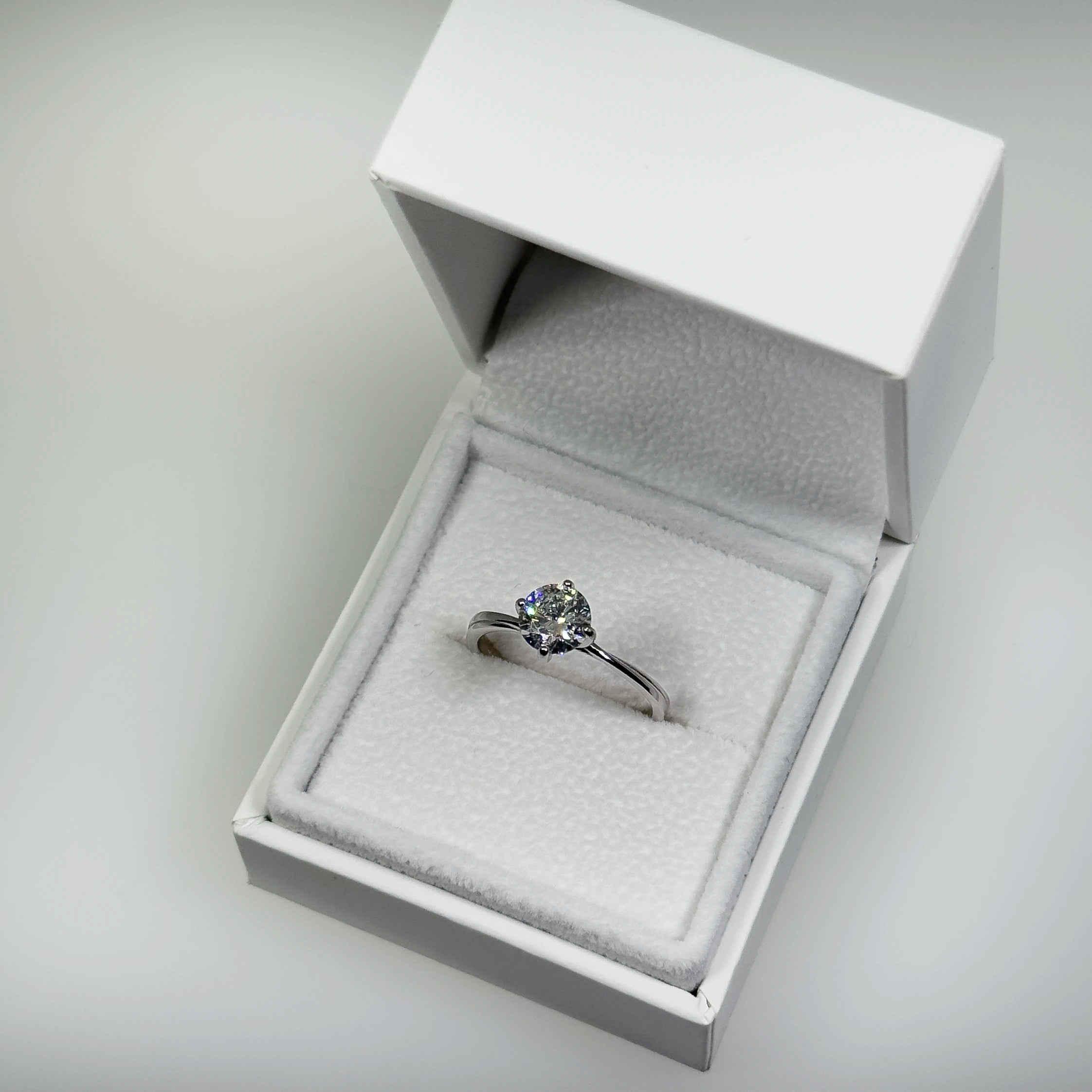 Hopeinen 1,03ct laboratoriotimanttisormus kuvattuna valkoisella korutelineellä