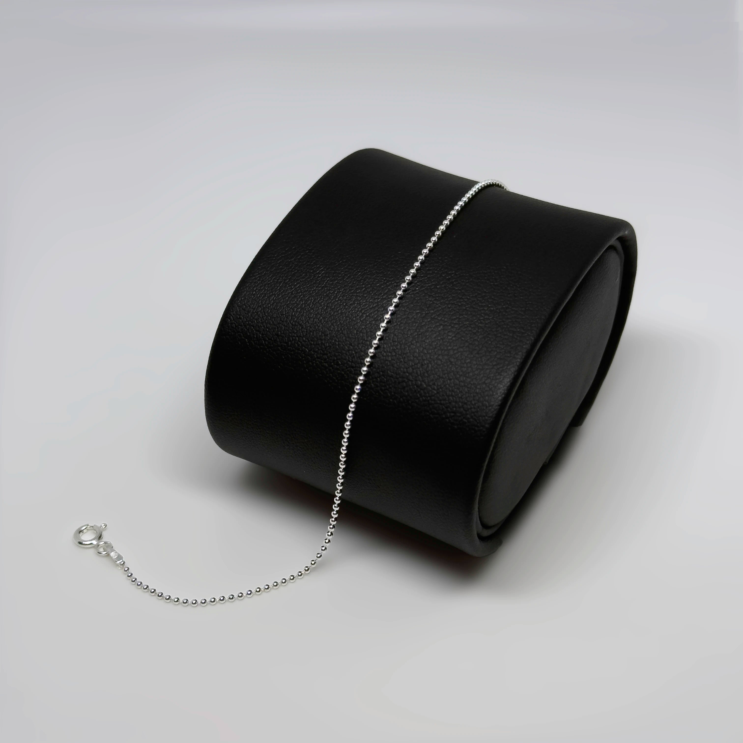 Hopeinen pallorannekoru kuvattuna mustalla korutelineellä