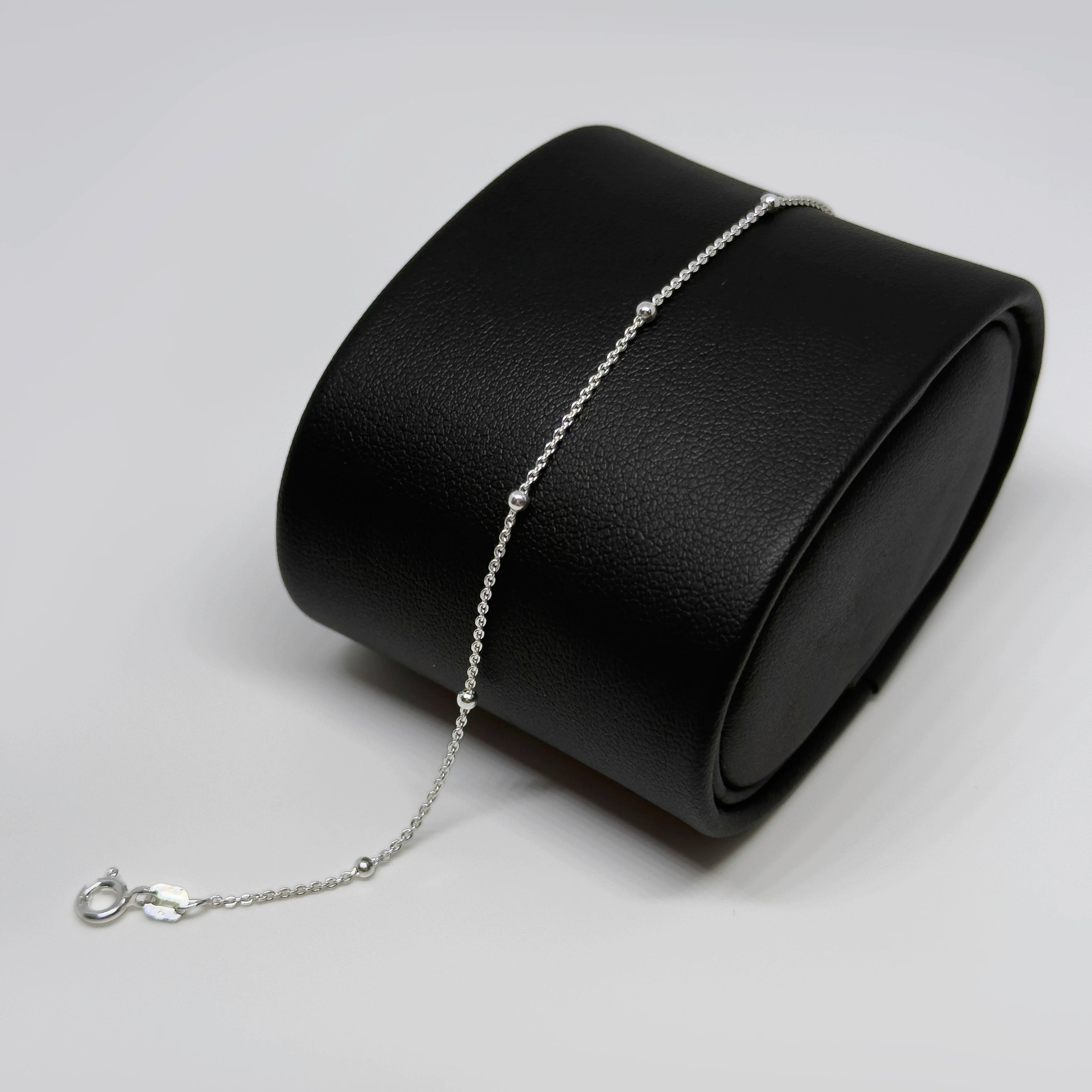 Hopeinen pallorannekoru kuvattuna mustalla korutelineellä