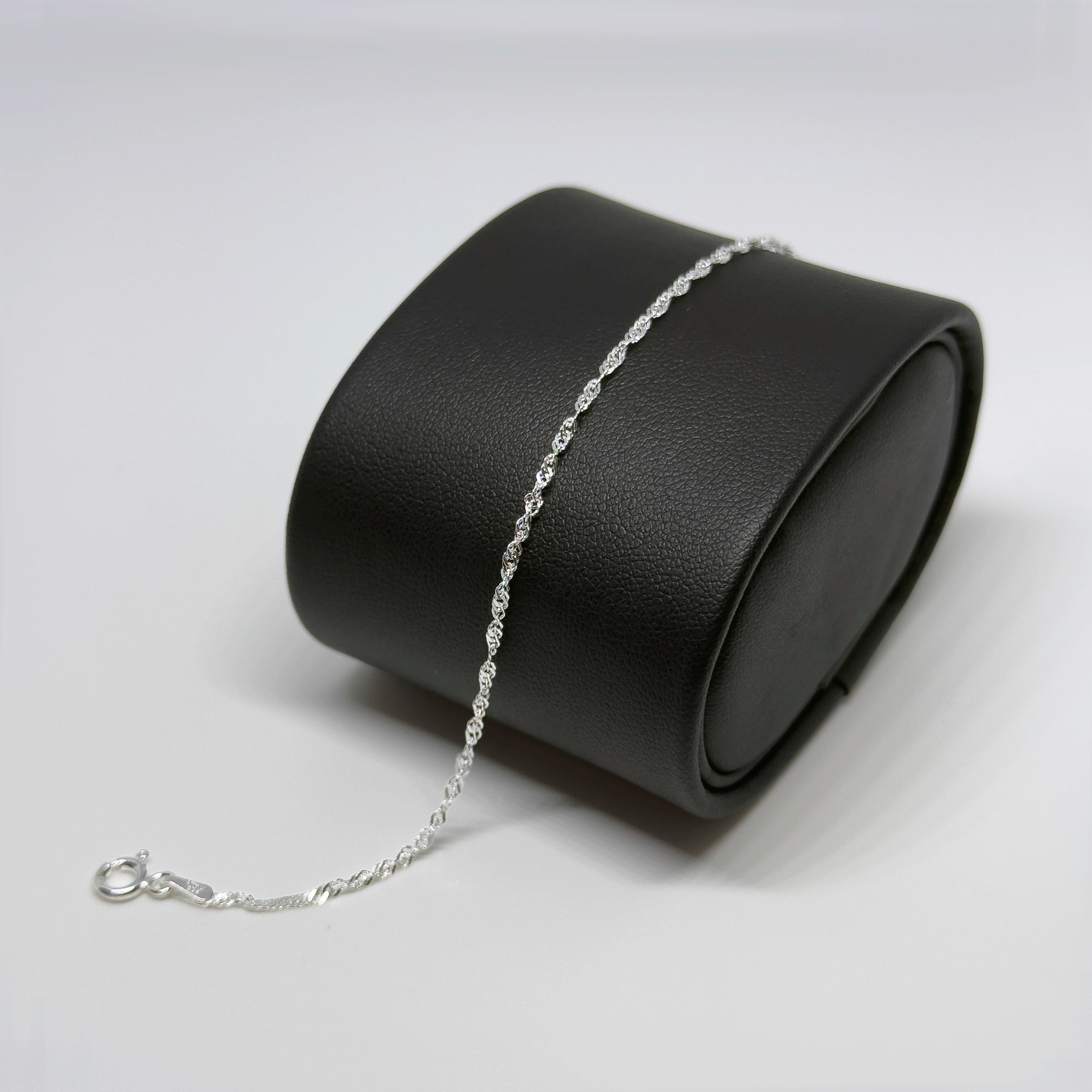 Hopeinen singaporerannekoru kuvattuna mustalla korutelineellä