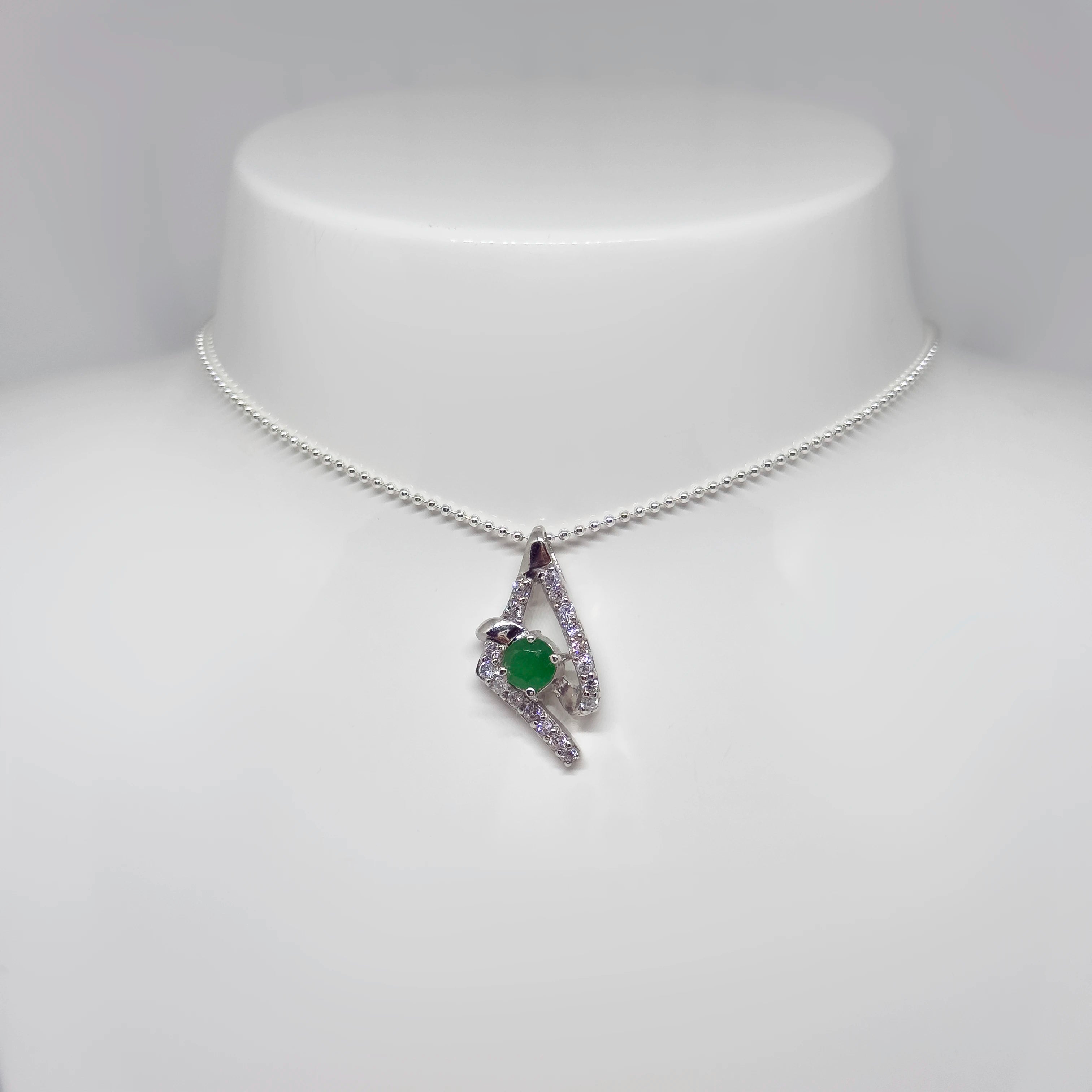 Hopeinen synteettinen smaragdi zirkonia riipus kuvattuna valkoisella korutelineellä