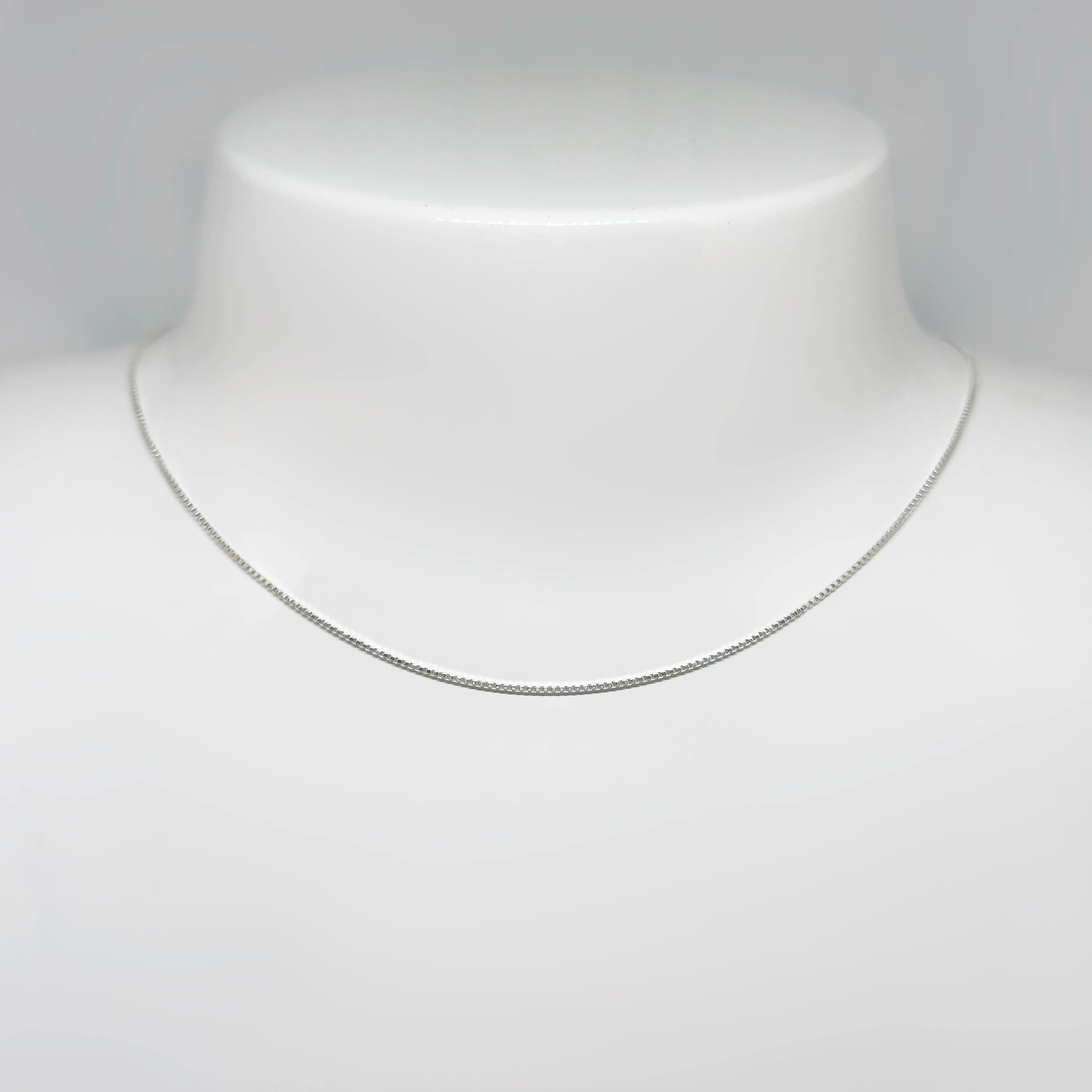 Hopeinen venetsiaketju kuvattuna valkoisella korutelineellä