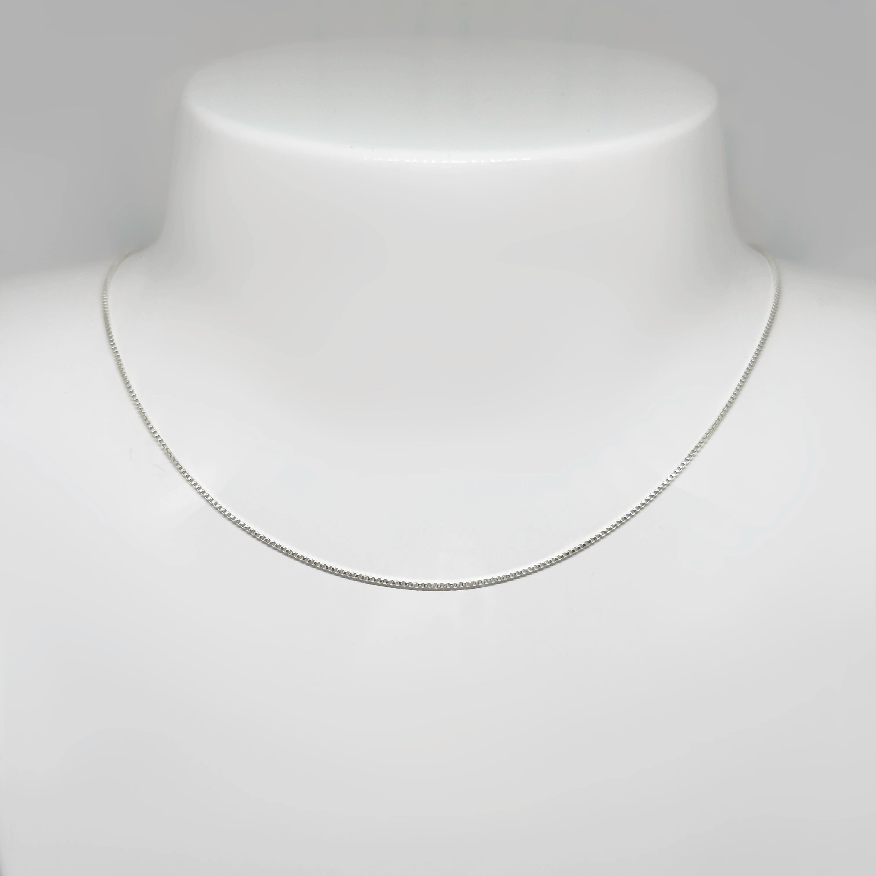 Hopeinen venetsiaketju kuvattuna valkoisella korutelineellä