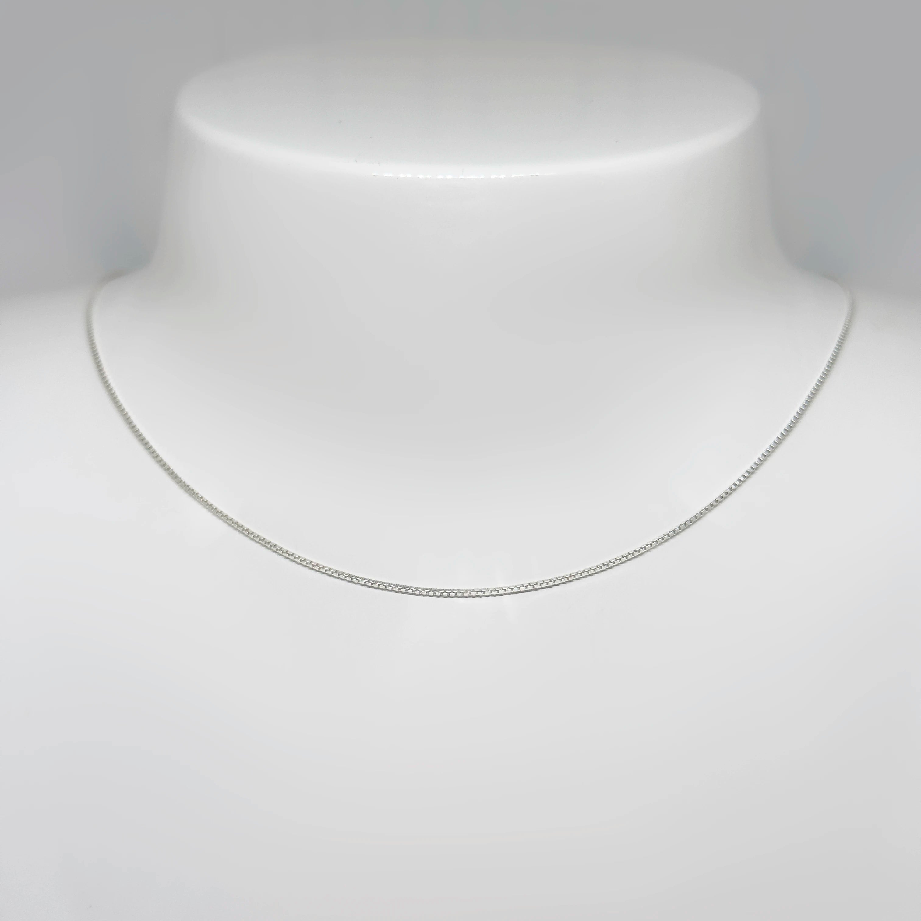 Hopeinen venetsiaketju kuvattuna valkoisella korutelineellä