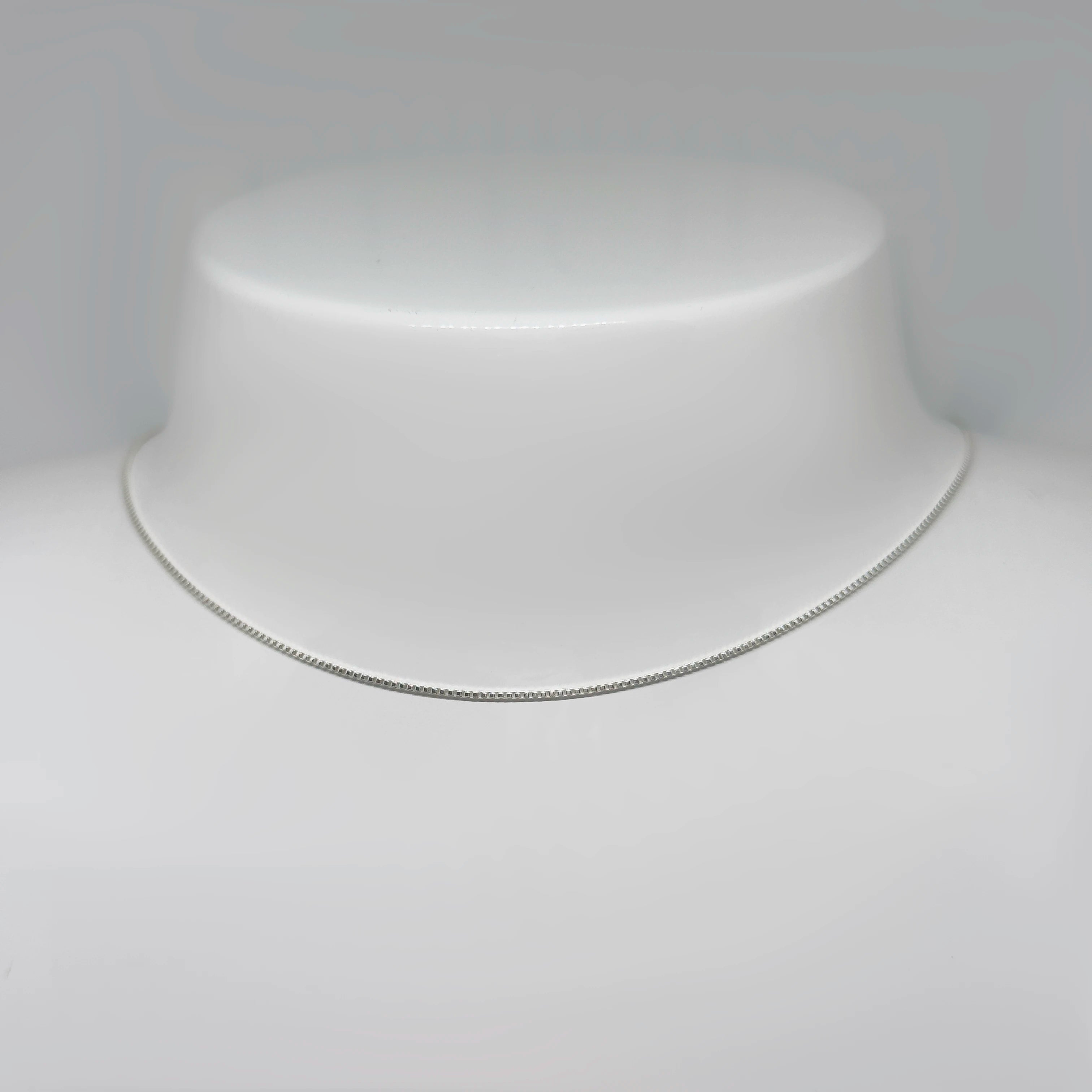 Hopeinen venetsiaketju kuvattuna valkoisella korutelineellä