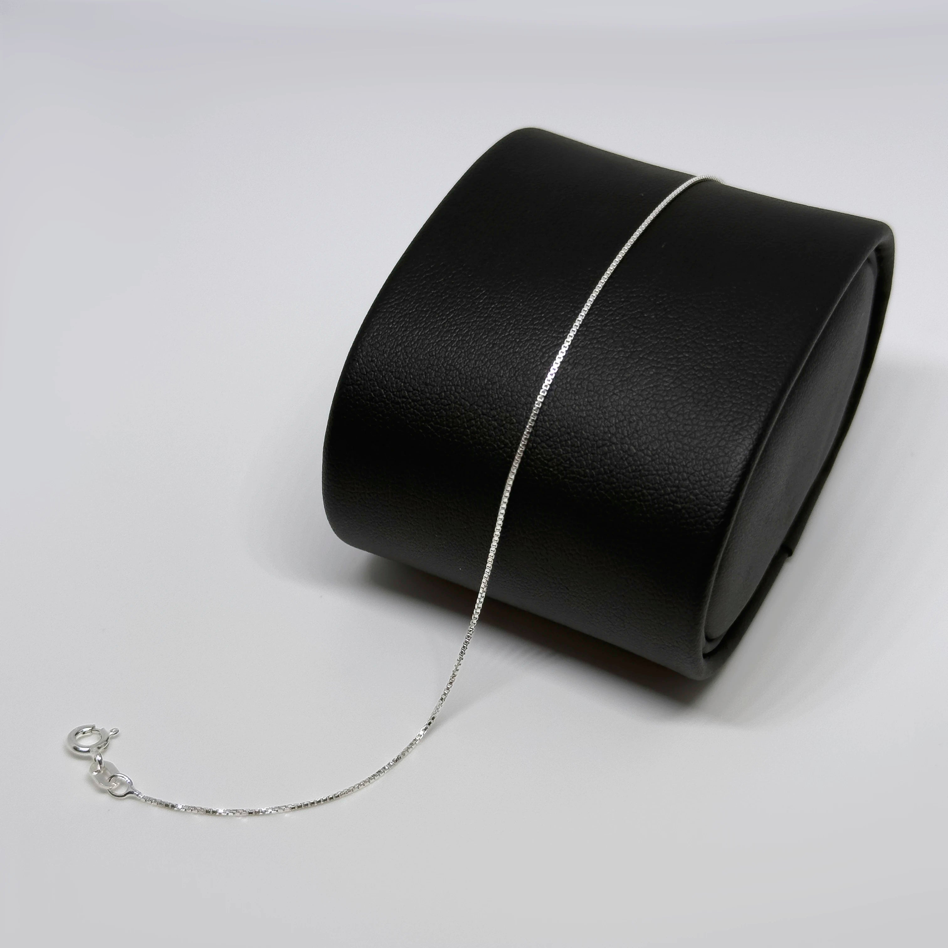 Hopeinen venetsiaketju rannekoru kuvattuna mustalla korutelineellä