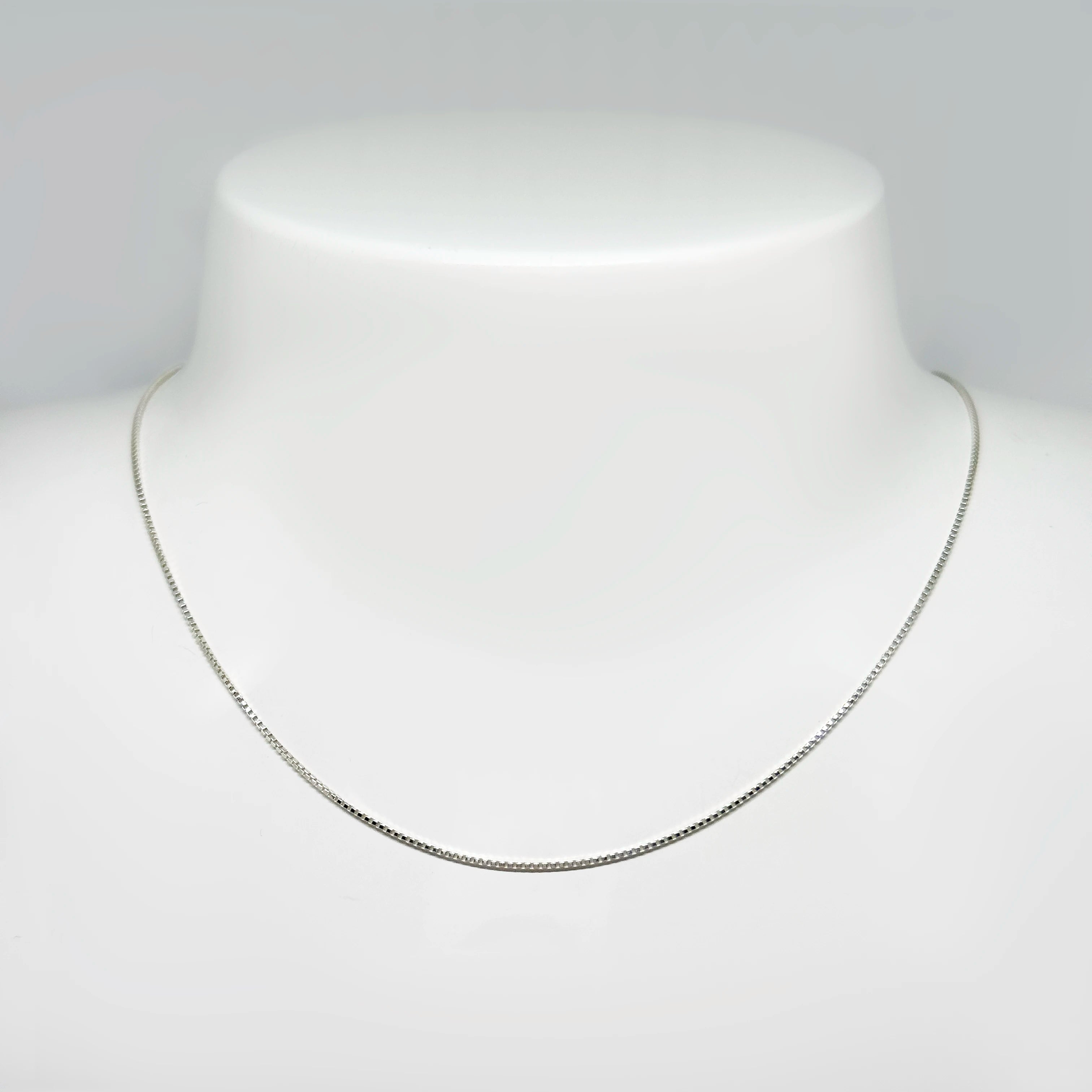 Hopeinen venetsiaketju kuvattuna valkoisella korutelineellä