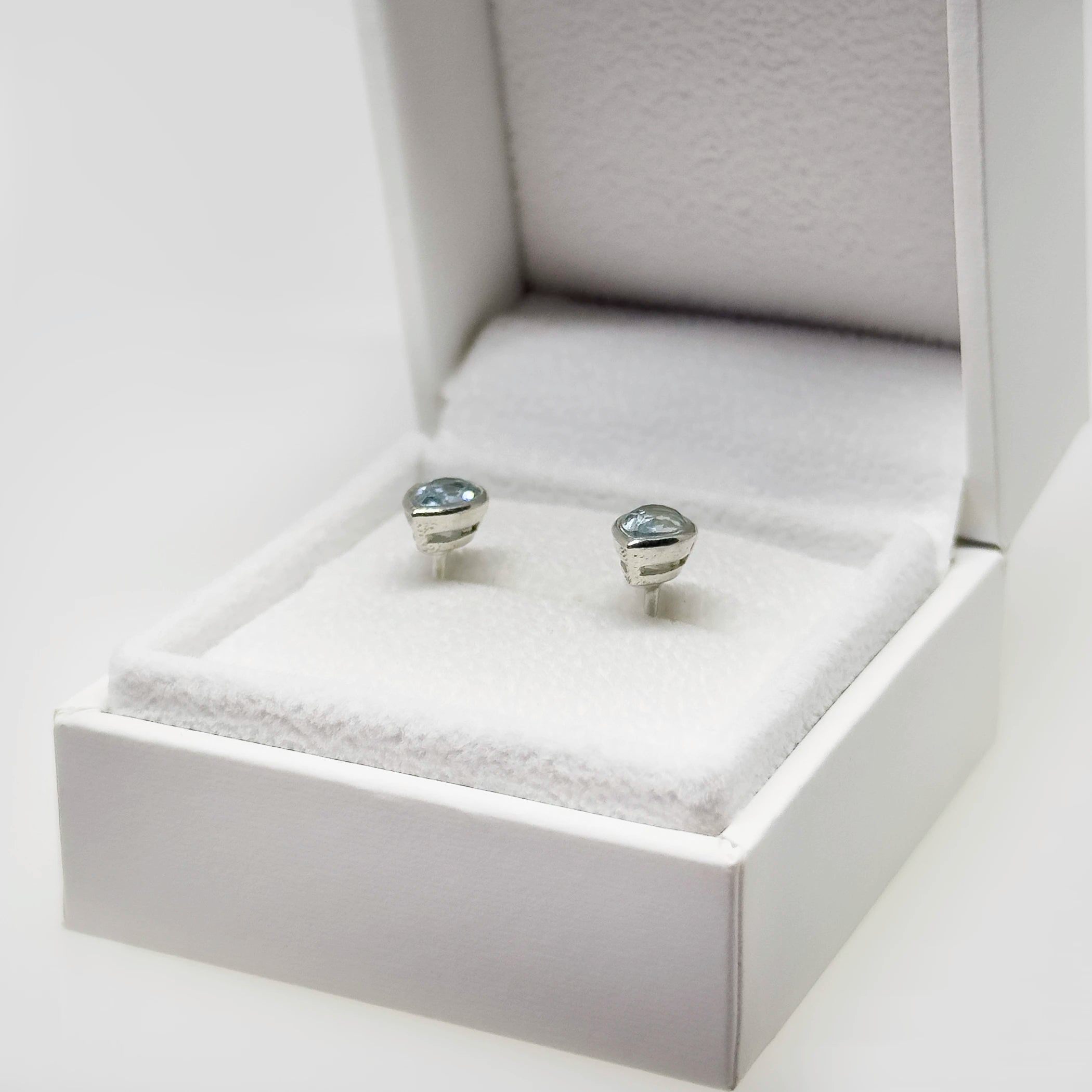 Hopeiset topaasi kyynel korvakorut kuvattuna valkoisella korutelineellä